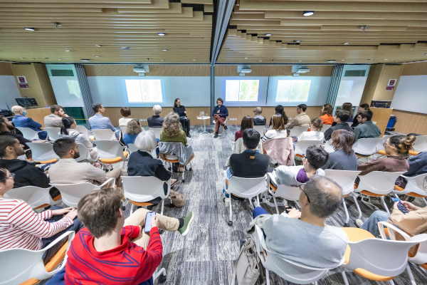 Audience watches author Nathan Thrall at the public talk on November 27