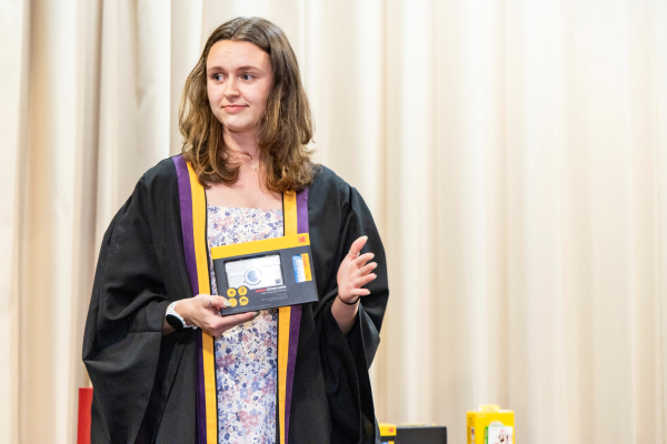 Junior Fellow Kait Roukey displaying the MC Photo Competition awards