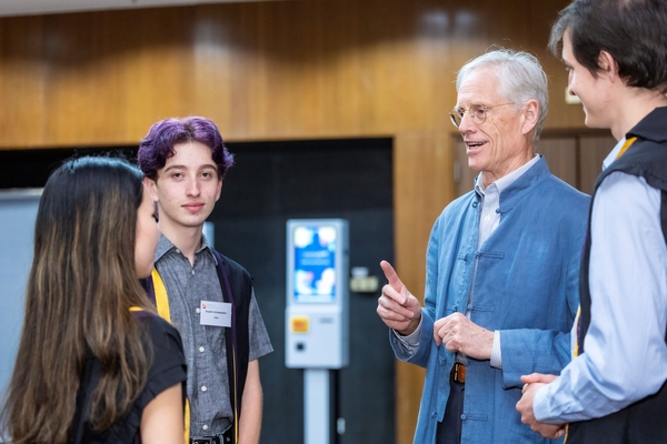 College Master Professor Nick Rawlins speaking with students and awardees.