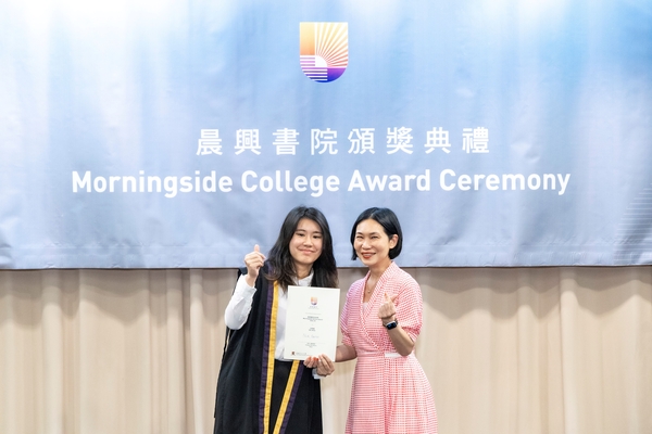 Student awardee taking a photo with a college fellow.