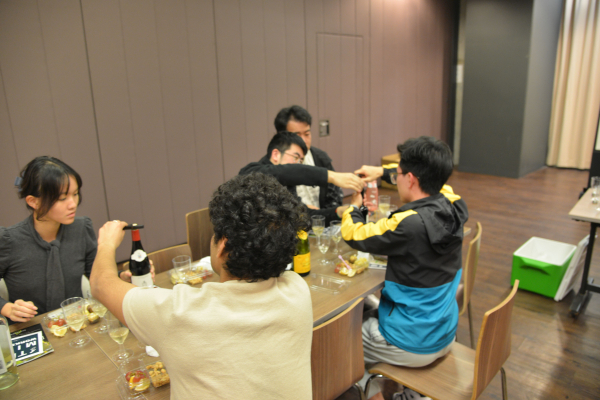 Students opening their bottles of wine.