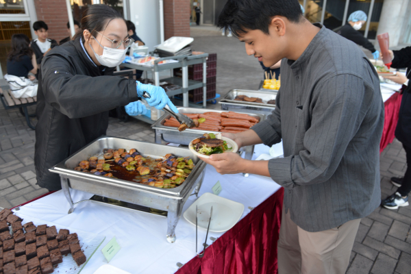 A student stands in line at the buffet.