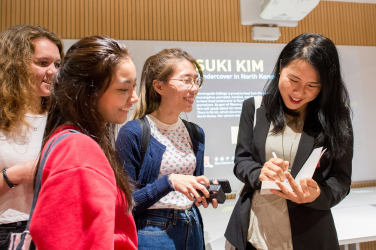 Students get their books signed by Suki Kim after the lecture